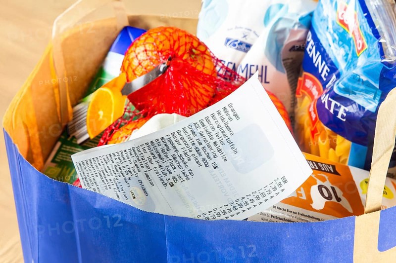 Symbolic image of food prices: Shopping bag full of groceries with a receipt