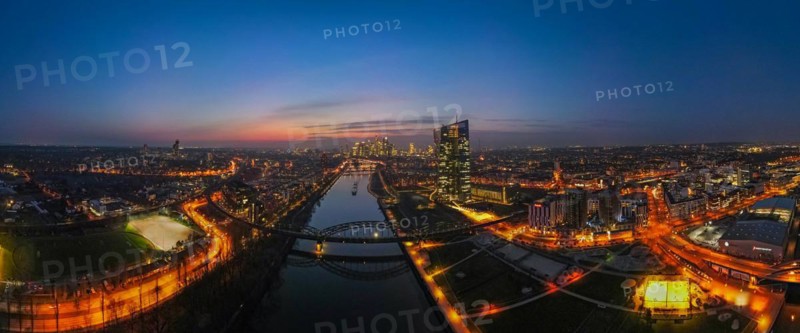 The lights of the European Central Bank (ECB) and the Frankfurt banking skyline glow in the evening. (Aerial view with a drone), Osthafen, Frankfurt am Main, Hesse, Germany, Europe