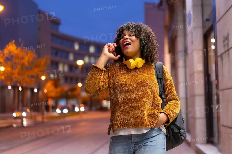 Portrait of black ethnic girl in the early morning going to the university on the way back to school talking on the phone
