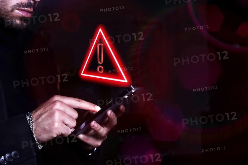 Hacker control and spying on your mobile phone. Symbol of caution in the use of cell phones.