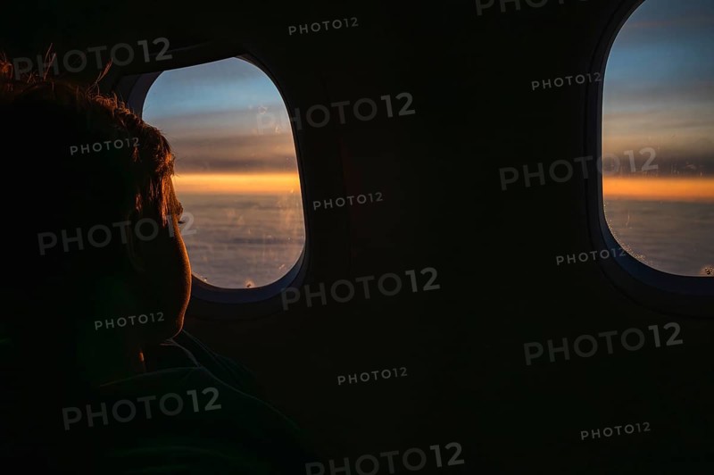 Boy looking throw the window in the flying airplane
