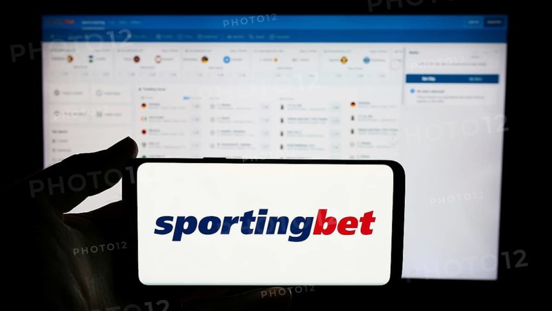 Stuttgart, Germany, 06-06-2024: Person holding cellphone with logo of British sports betting company Sportingbet plc in front of business webpage. Focus on phone display, Europe