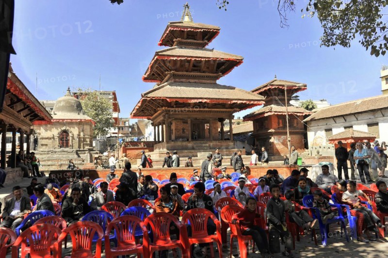 Group of people sitting on plastic chairs in front of a traditional temple, Kathmandu Valley, Kathmandu, Nepal, Asia