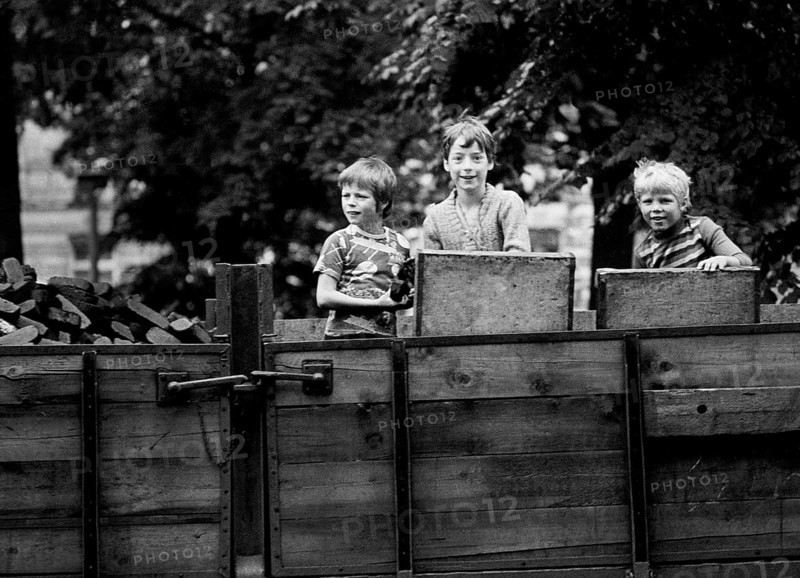 14/03/1982 GDR East Berlin district of Prenzlauer Berg. Three boys playing on a parked coal wagon with briquettes. Berlin