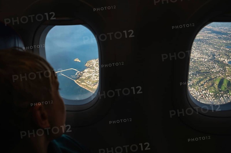 Boy looking throw the window in the flying airplane