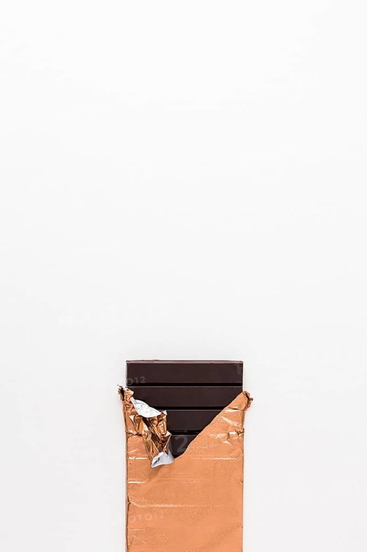 Dark chocolate bar golden wrapper white background