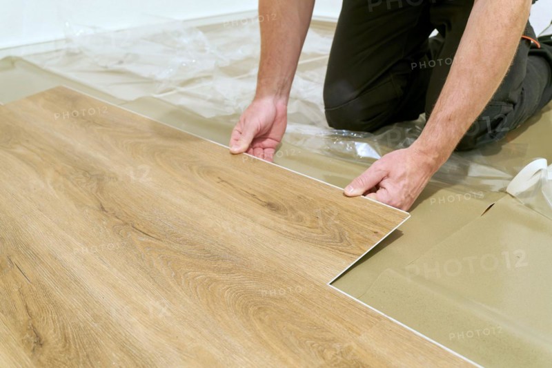 Craftsmen renovating a flat and laying click vinyl flooring