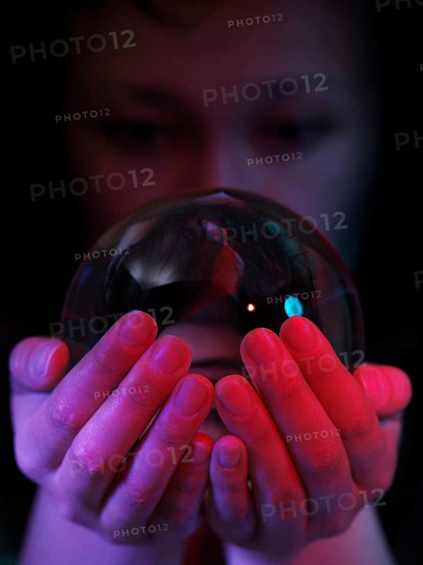 Woman looking into a crystal ball in her hands