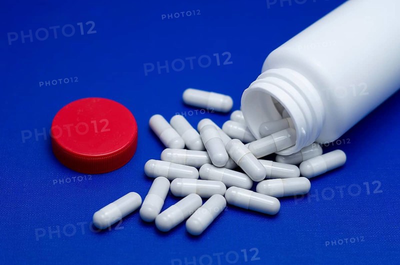 Large white pills fell from a large white bottle. Life without drugs and dependence on capsules of antibiotic, medicine, amphetamines, drugs and drugs. Concept of drug withdrawal drugs. Bulgaria