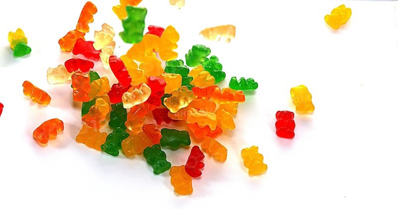 Gold Bears or Gummy Bears falling against White Background