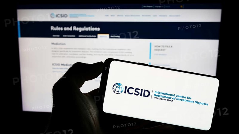 Stuttgart, Germany, 08-05-2023: Person holding cellphone with logo of World Bank's institution ICSID on screen in front of webpage. Focus on phone display, Europe