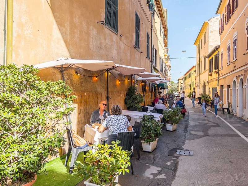 Guests at the tables in front of the restaurants in Via Roma, Orbetello, Tuscany