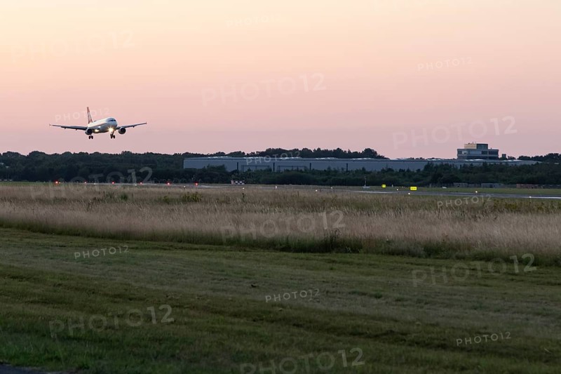 Passenger aircraft Airbus A320-214 of Austrian Airlines at dusk during landing at Hamburg Airport, Hamburg, Germany, Europe