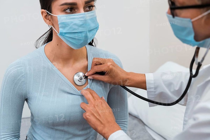 Woman checking patient with stethoscope