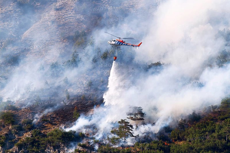 Helicopter dumping water during a forest fire, Tyrol, Austria, Europe