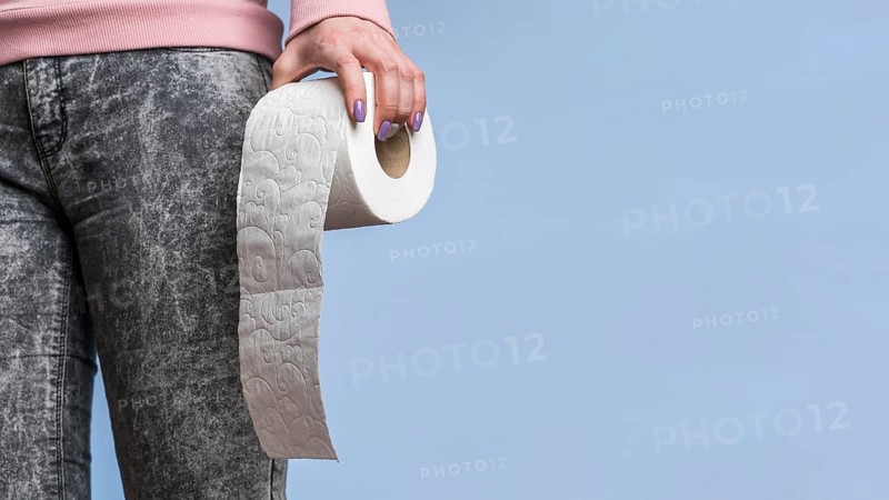 Front view person holding toilet paper roll with copy space