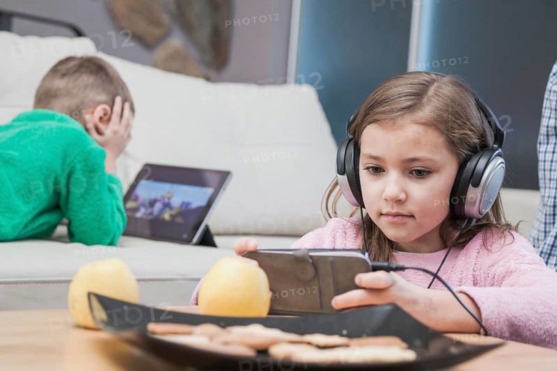 Kids using technologies living room