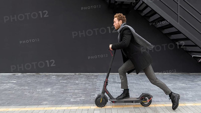 Handsome male riding electric scooter