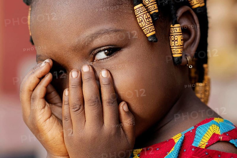 Close up african girl covering her face