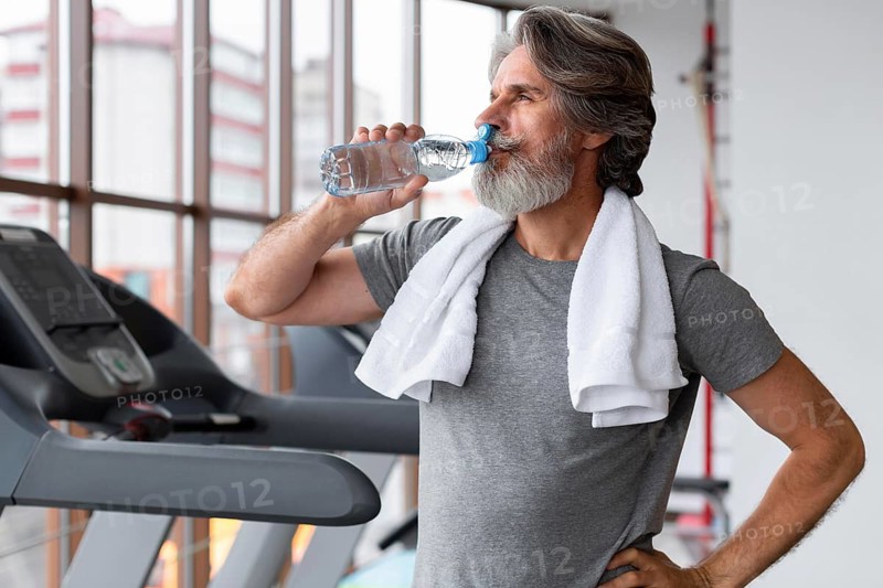 Medium shot man drinking water gym
