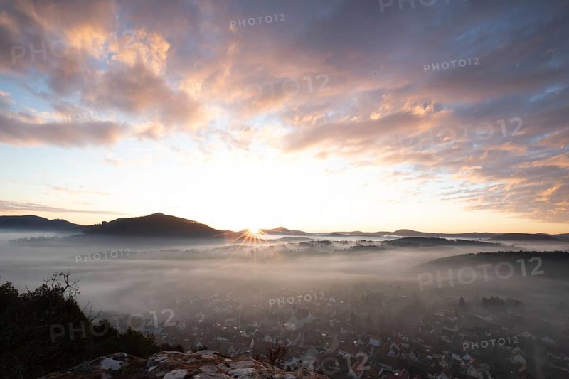Mystical sunrise at the Wachtfelsen. Fascinating landscape shot between fog and clouds near Wernersberg, Pfälzerwald, Germany, Europe