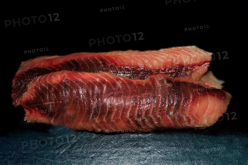 Trimmed fillets of grass carp (Ctenopharyngodon idella), also known as white Amur, wild catch from Myramar, food photography with black background