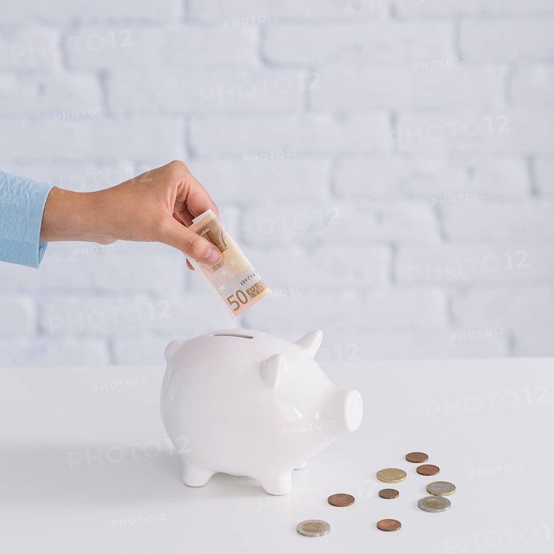 Close up woman s hand inserting fifty euro banknote piggybank desk. Beautiful photo