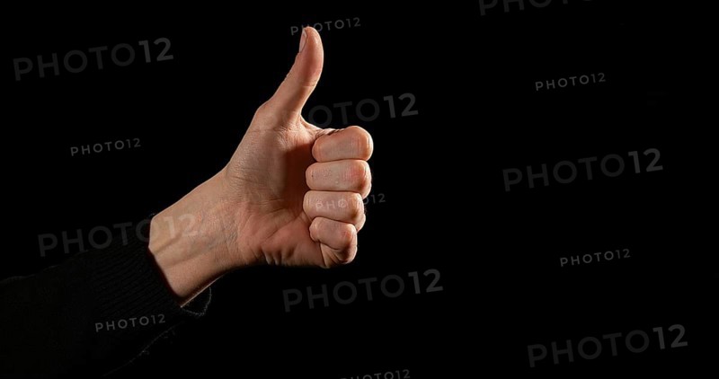 Hand of Woman making Sign against Black Background