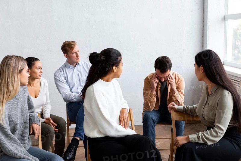Sad man talking about his issues group therapy session