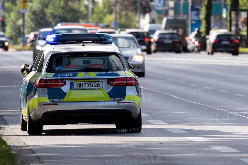 Police car in action with blue lights parked on a main road in Hamburg, Germany, Europe