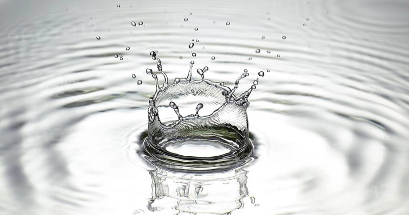Drop of Water falling into Water against Grey background