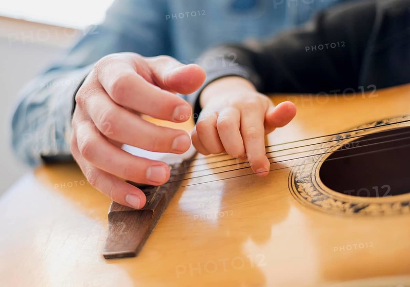 Low angle teacher child holding guitar