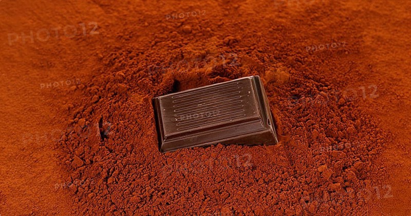 Black Chocolate Tablet falling on Black Chocolate Powder