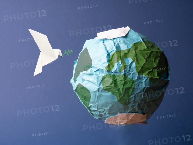Abstract globe made of crumpled paper with origami peace dove, global freedom and peace concept