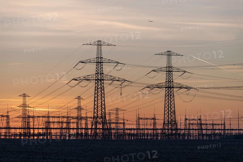 Rows of high-voltage pylons stretch into the twilight, Wolmirstedt substation, Saxony-Anhalt, Germany, Europe