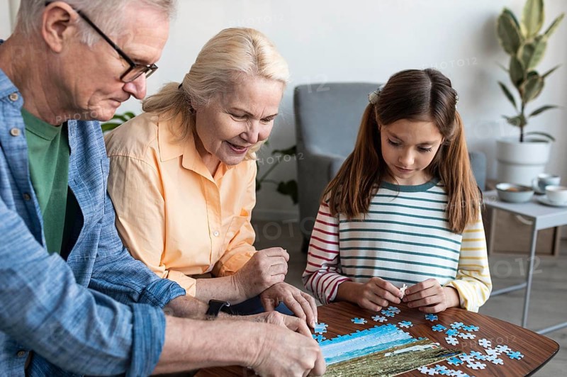 Grandparents girl doing puzzle close up