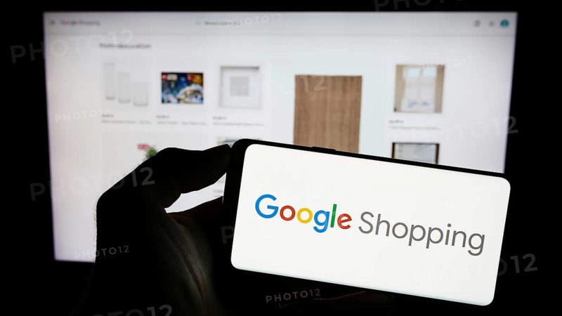 Stuttgart, Germany, 09-23-2023: Person holding mobile phone with logo of product search platform Google Shopping on screen in front of company web page. Focus on phone display, Europe