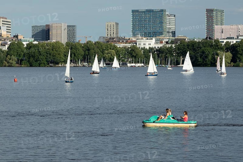Symbolic picture weather, leisure activities in summer, people in a pedal boat, behind them sailing boats against a blue sky on the Alster in Hamburg, Germany, Europe