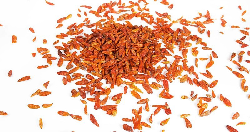 Cayenne Chili Pepper (capsicum frutescens), spice falling against White Background