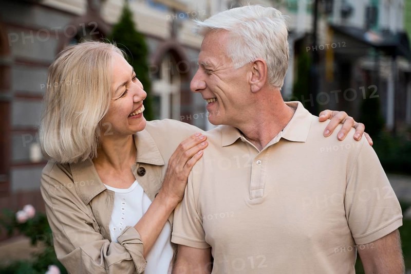 Smiley elder couple taking walk city together