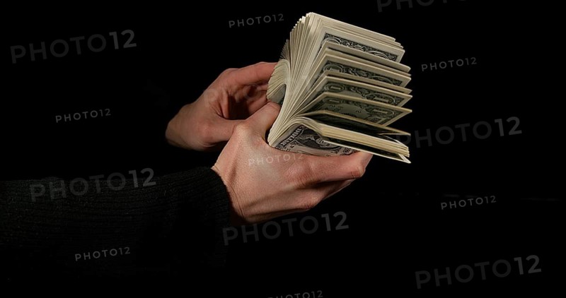 Hand of Woman and Dollar Bank Notes against Black Background