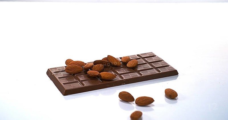 Almonds falling on Milk Chocolate tablet