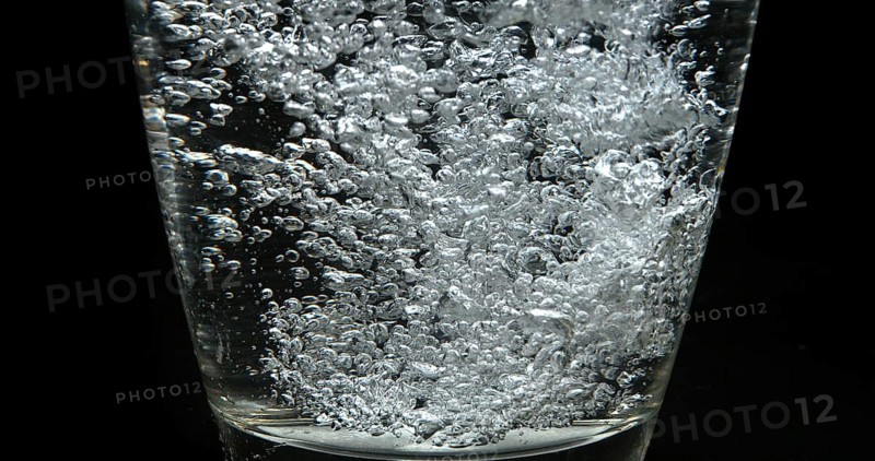 Water being poured into Glass against Black Background