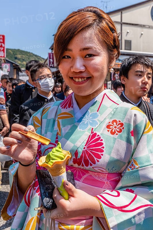 Kyoto Japan. Smiling woman wearing traditional kimono, eating an ice cream