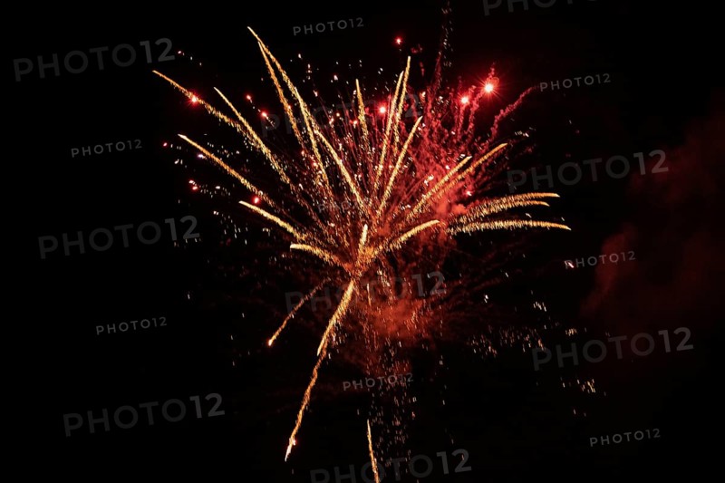 New Year's Eve fireworks night sky with golden and reddish sparks
