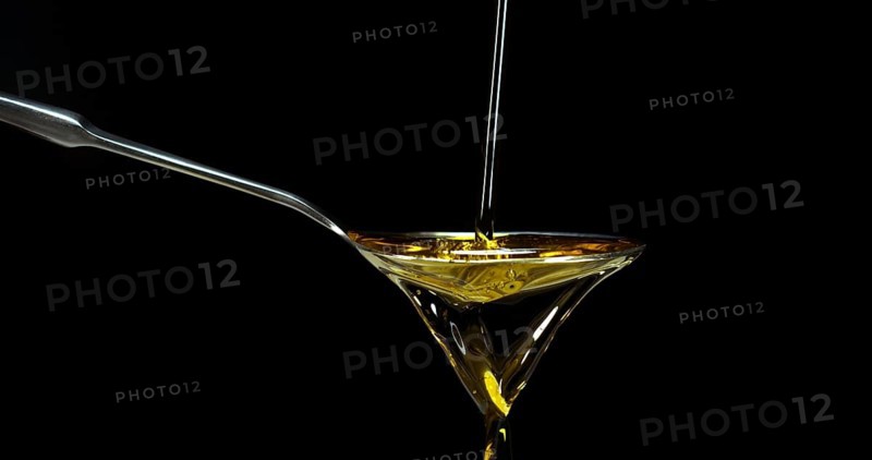 Olive Oil, Falling in a Spoon against Black Background