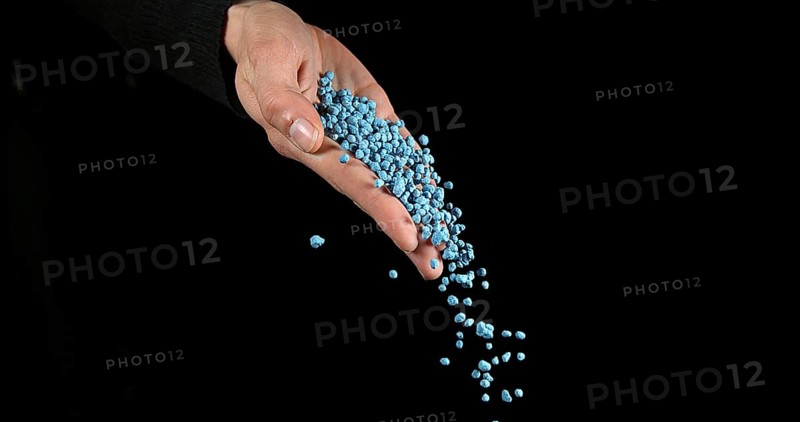 Hand of Woman with Soil Fertilizer against Black Background