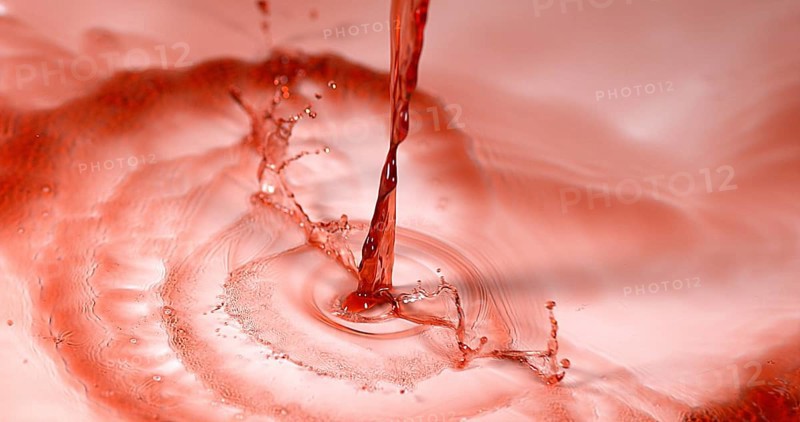 Red Wine being poured against White Background