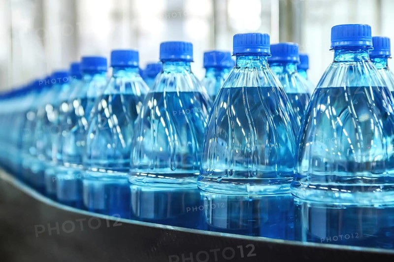 Closeup on mineral water green bottles in raw and lines
