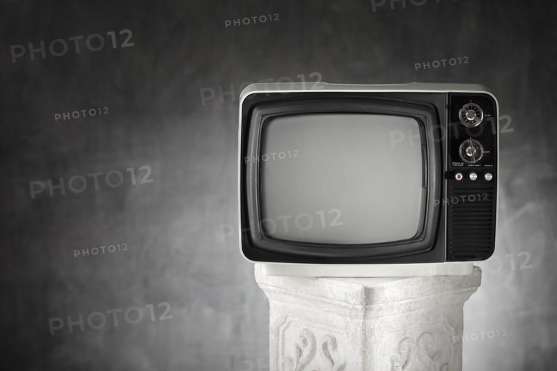 Old portable television on a plaster column